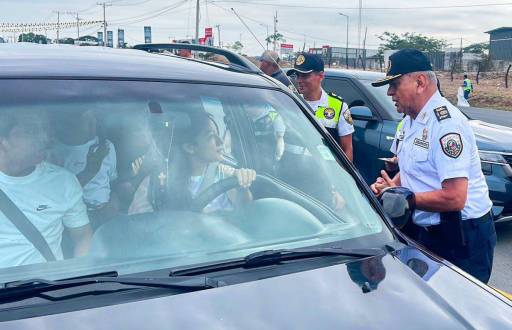 Imagen de agentes de la Comisión de Tránsito del Ecuador (CTE) conversando con una conductora en una vía del Ecuador.