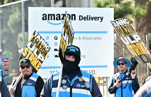 Trabajadores de Amazon caminan por la línea de piquete fuera de una instalación de Amazon en la ciudad de Industry, California.