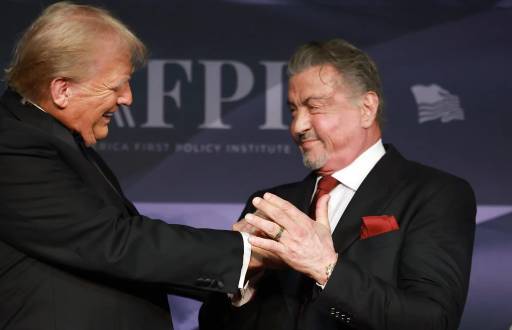 El presidente electo de Estados Unidos, Donald Trump, saluda al actor Sylvester Stallone en el escenario de la Gala del America First Policy Institute celebrada en Mar-a-Lago