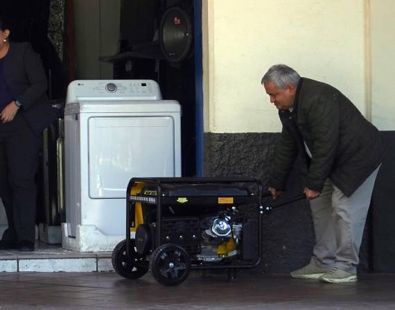 Personas movilizando un generador eléctrico.