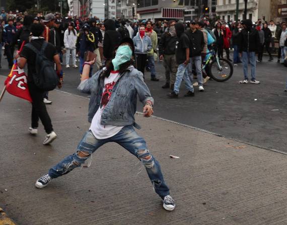 Un manifestante se enfrenta a integrantes de la Policía Nacional en una marcha de este jueves.