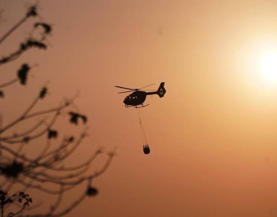 Imagen de helicóptero Arpía Ala 21 de la FAE con sistema bambi bucket combatiendo las llamas desde el aire, en la zona del Cerro Azul en Guayaquil, este lunes 2 de diciembre.