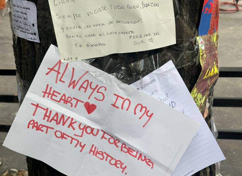 Fanáticas pegan cartas en el árbol de la acera del hotel donde murió Liam Payne.