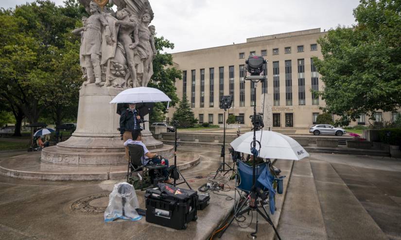 Miembros de la prensa esperan bajo la lluvia frente al tribunal federal de DC en Washington DC, Estados Unidos