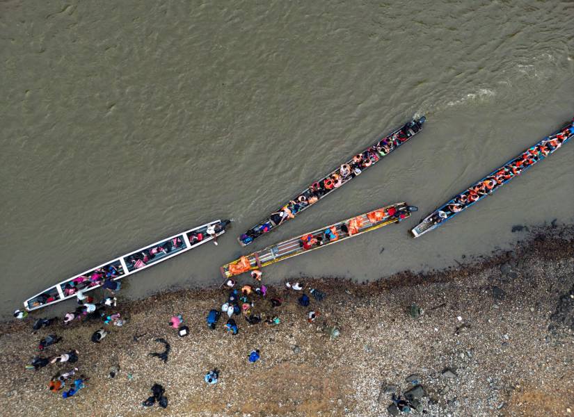 Migrantes se embarcan en canoas para recorrer torrentosos ríos, en su ruta hacia Estados Unidos.