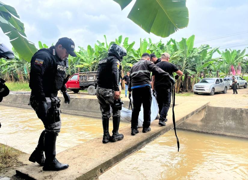 Imagen de agentes policiales recogiendo el cuerpo de un hombre armado con fusil en una bananera en Pasaje, El Oro, el sábado 21 de diciembre.