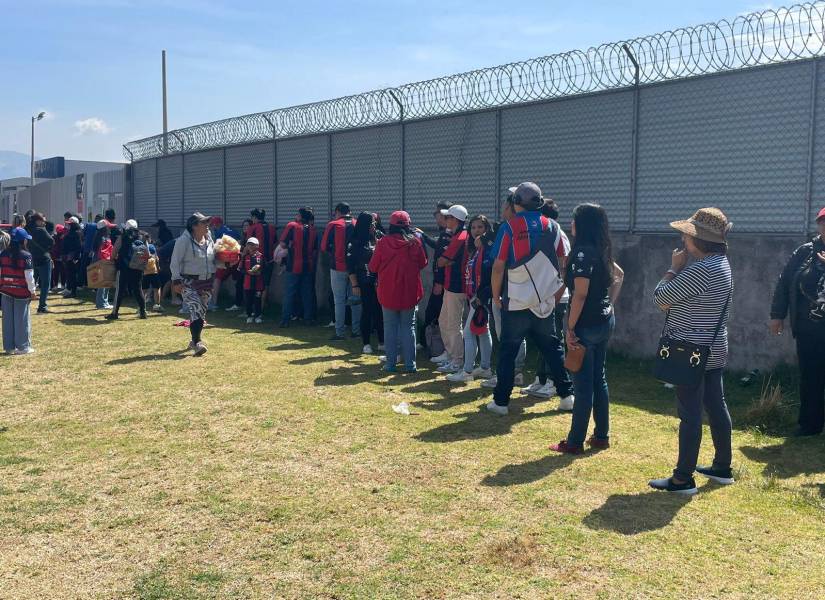 Hinchas del deportivo Quito esperando que las puertas del estadio IDV se abran