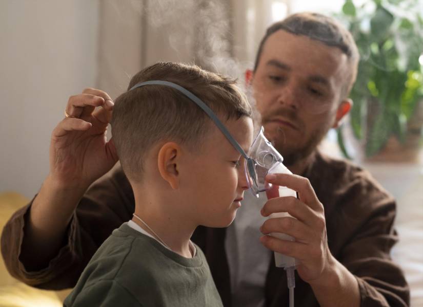 Niño junto a su padre colocándolo el nebulizador