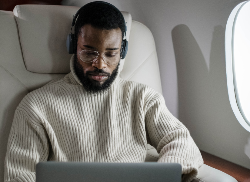 Imagen referencial de hombre trabajando en su laptop mientras viaja en avión.