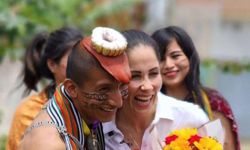 Imagen de un indígena tsáchila bromeando con meter carpeta con Luisa González.