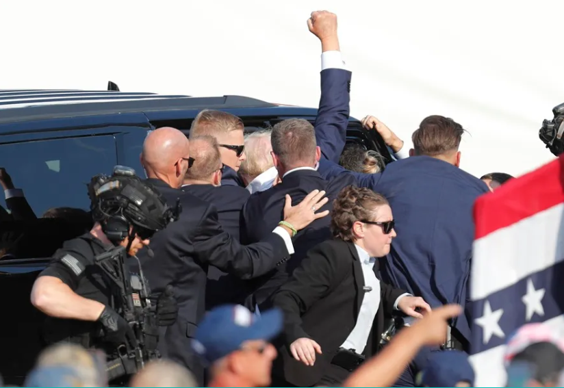 El expresidente estadounidense Donald Trump evacuado del escenario por su servicio secreto.