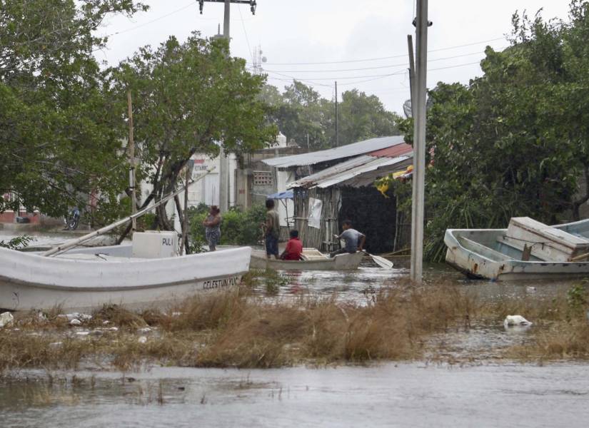 Un grupo de personas se traslada en lancha por una calle inundada tras el paso del huracán Milton.