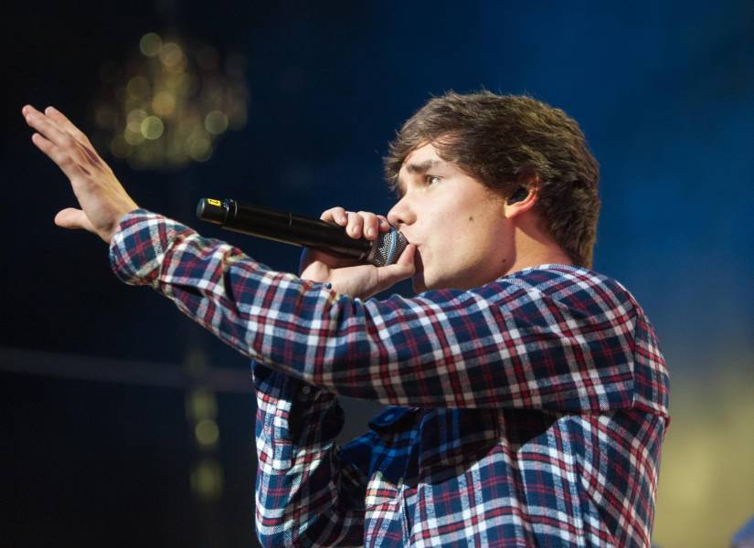 Archivo. Liam Payne en la foto (camisa a cuadros) en 2012 en Glasgow, Escocia, como parte de la gira One Direction después de ganar X Factor en el Reino Unido.