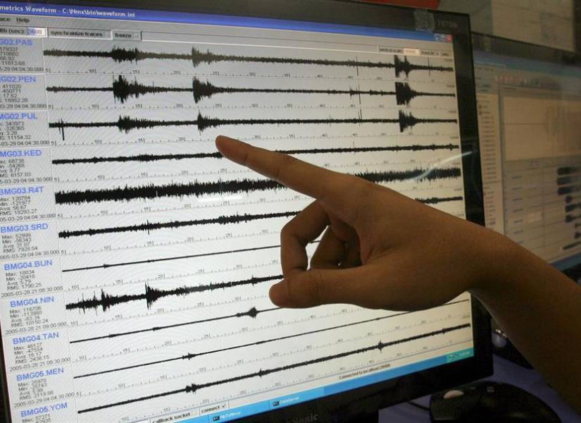 Foto referencial en la que sismólogos muestran un gráfico de un sismo.