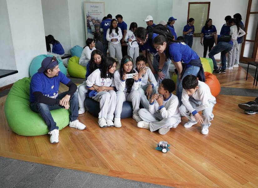 Niños y niñas junto a los voluntarios armando un robot y posterior programación para lograr su movimiento.