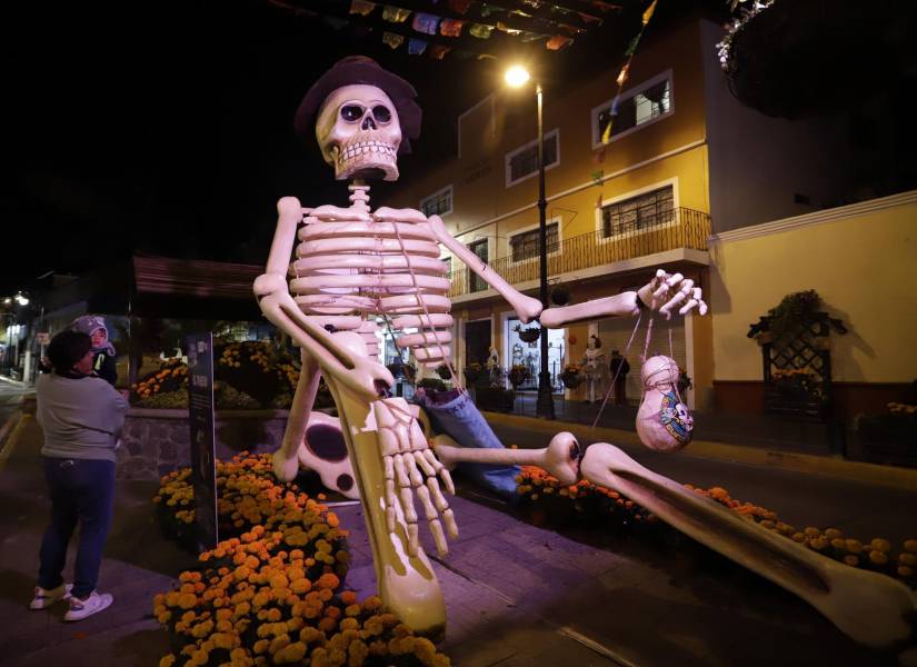 Visitantes observan calaveras gigantes colocadas en Puebla, México.