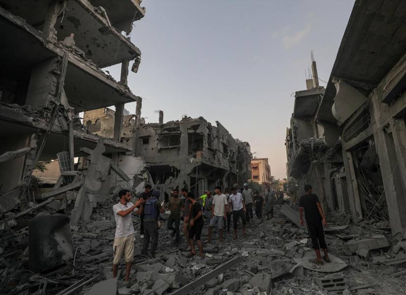 Palestinos inspeccionan casas dañadas tras un ataque aéreo israelí.