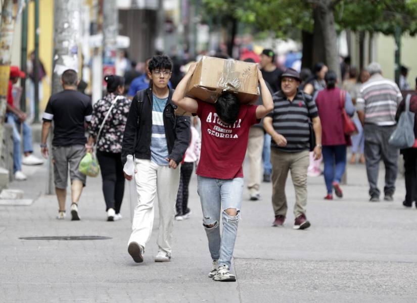 Un hombre carga una caja por una calle este miércoles en Tegucigalpa (Honduras).