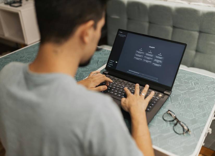 Imagen referencial de hombre usando computadora portátil con ChatGPT.