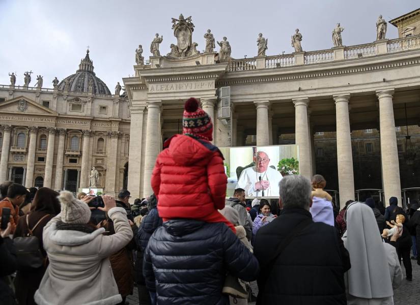 Feligreses siguen en la plaza de San Pedro el rezo del ángelus del papa Francisco.