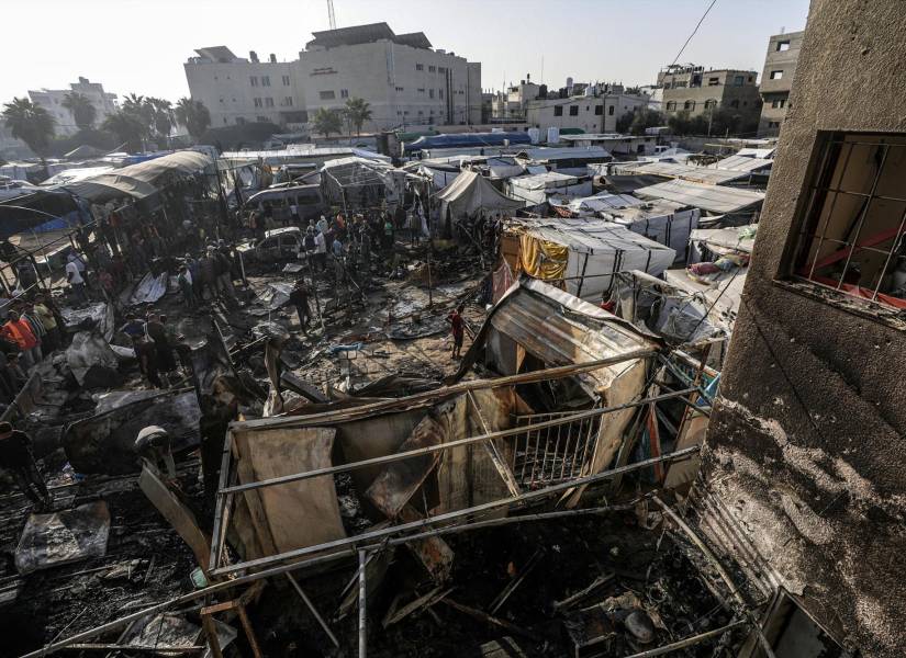 Palestinos inspeccionan tiendas de campaña improvisadas destruidas en un campamento.