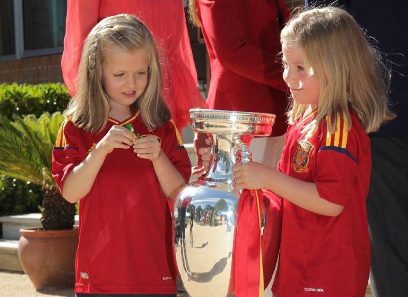 La princesa Leonor y la infanta Sofía cargando el trofeo de la Eurocopa 2012.