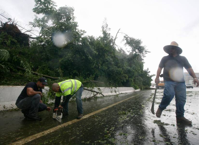 Un grupo de trabajadores limpian las carreteras, tras el paso de una tormenta en Puerto Rico. Imagen de archivo.