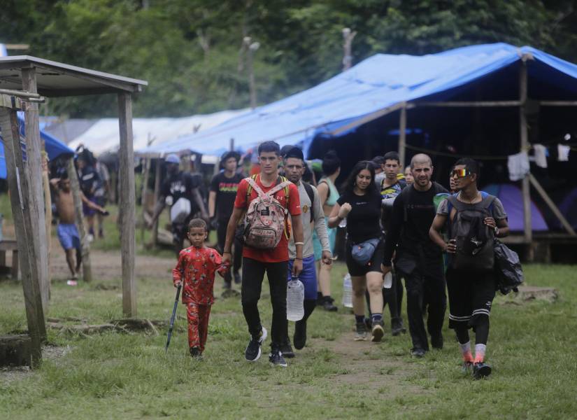 Migrantes de diferentes nacionalidades cruzan un campamento en medio de un operativo este sábado en plena selva del Darién, frontera natural entre Colombia y Panamá.