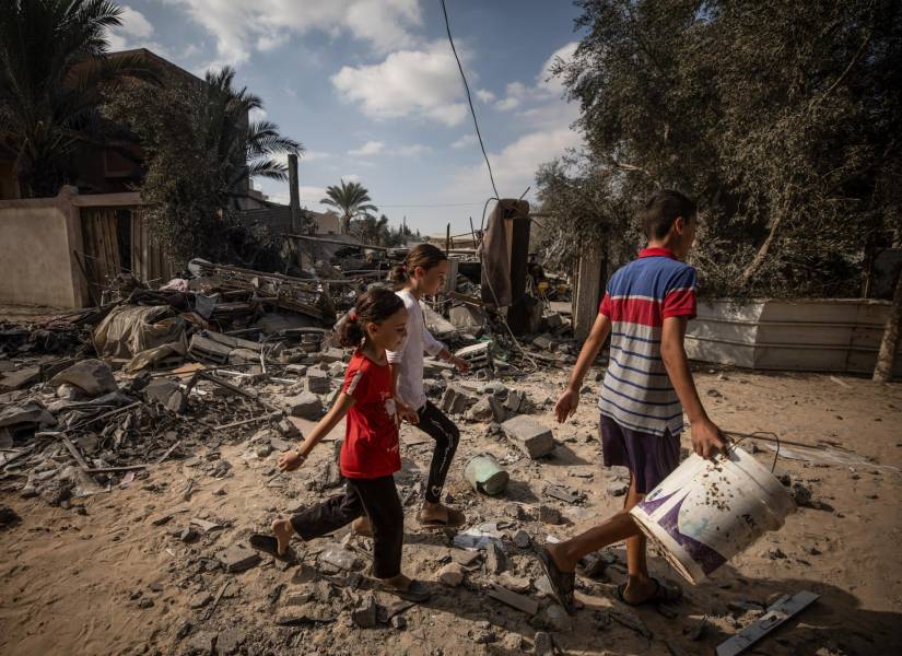 Niños palestinos caminan entre los escombros en Deir Al Balah, en la Franja de Gaza.