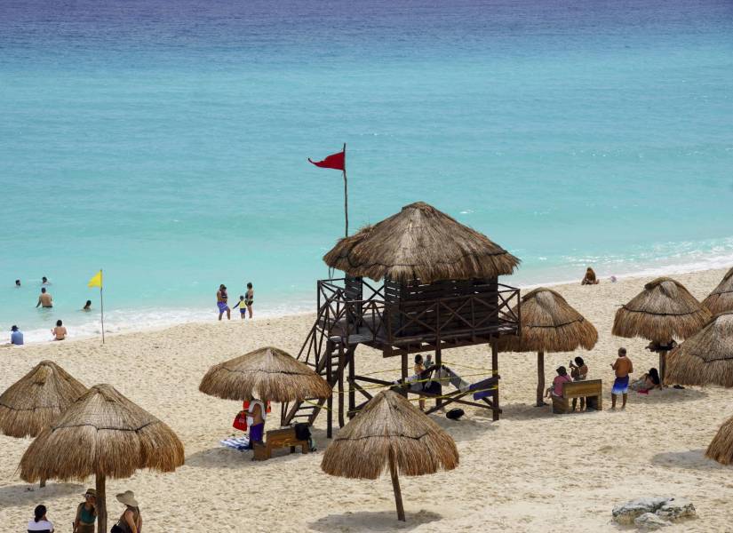 Una bandera roja advierte de la llegada del huracán Milton en una playa de Cancún, México.