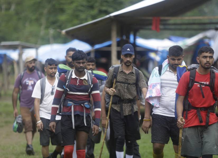 Migrantes de diferentes nacionalidades cruzan un campamento en medio de un operativo este sábado en plena selva del Darién, frontera natural entre Colombia y Panamá.