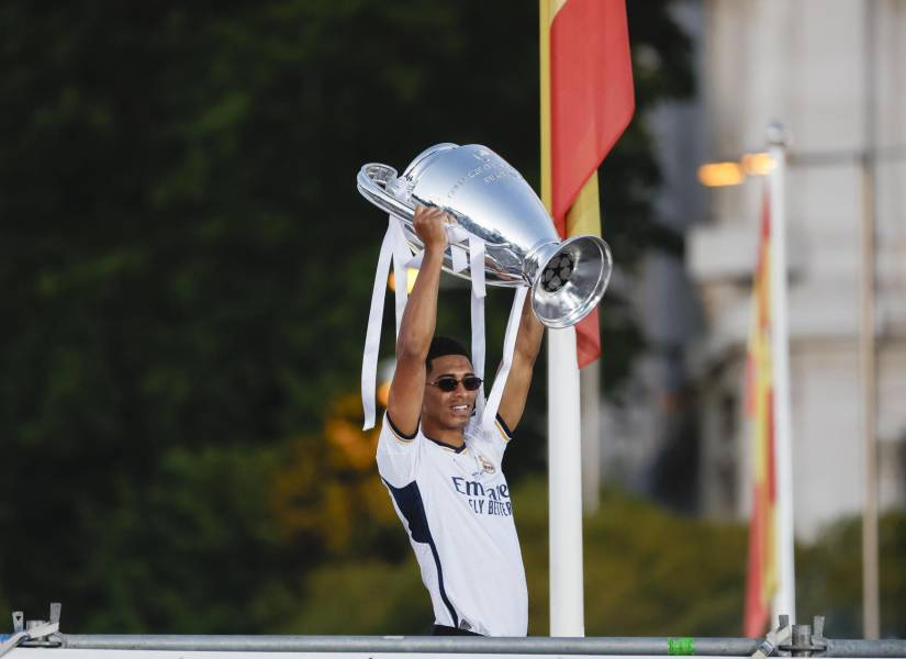 El centrocampista británico del Real Madrid Jude Bellingham levanta el trofeo este domingo en la Plaza de Cibeles para celebrar con la afición su victoria en la final de la Liga de Campeones.