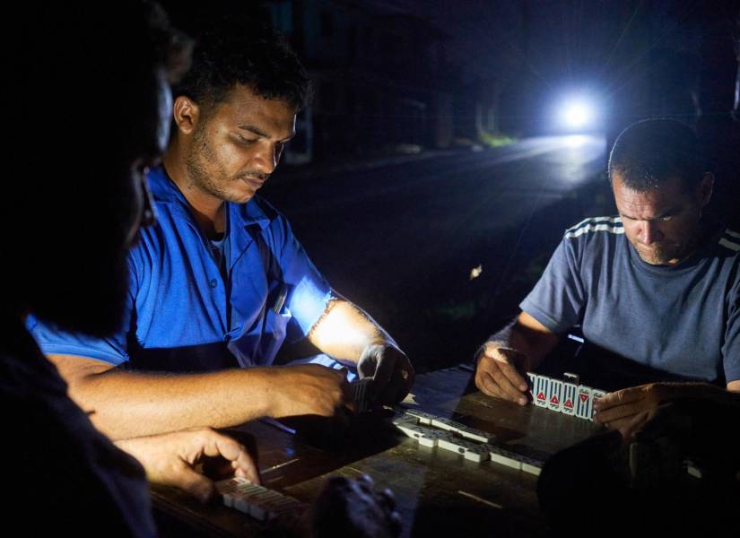 Residentes de Naranjal Norte juegan dominó en la calle, en penumbras, por falta de energía en la provincia de Matanzas, Cuba.