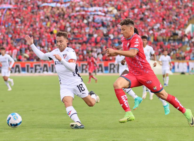 Ezequiel Piovi, volante de Liga de Quito, disputa el balón con Byron Palacios