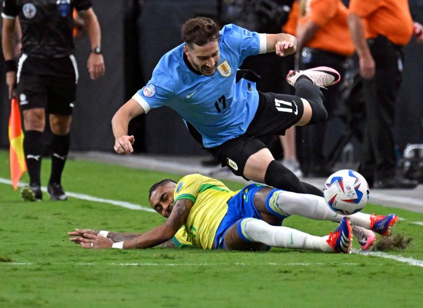 El delantero brasileño Raphinha lucha por el balón con el defensor uruguayo Matías Viña.