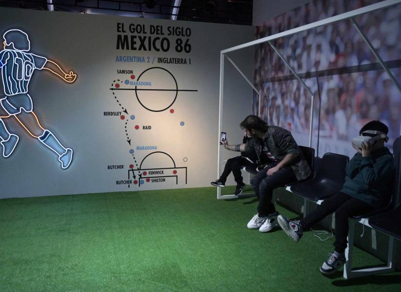 La gente usa gafas de realidad virtual para ver el segundo gol de Diego Maradona contra Inglaterra durante la Copa Mundial de la FIFA México 86 en la exhibición.