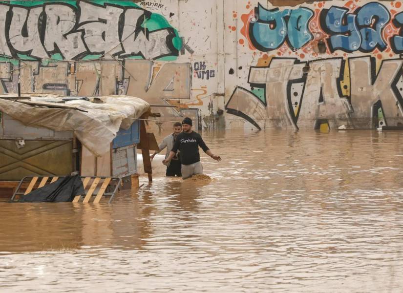 Ciudadanos intentando cruzar por la calle que ahora parece un río.