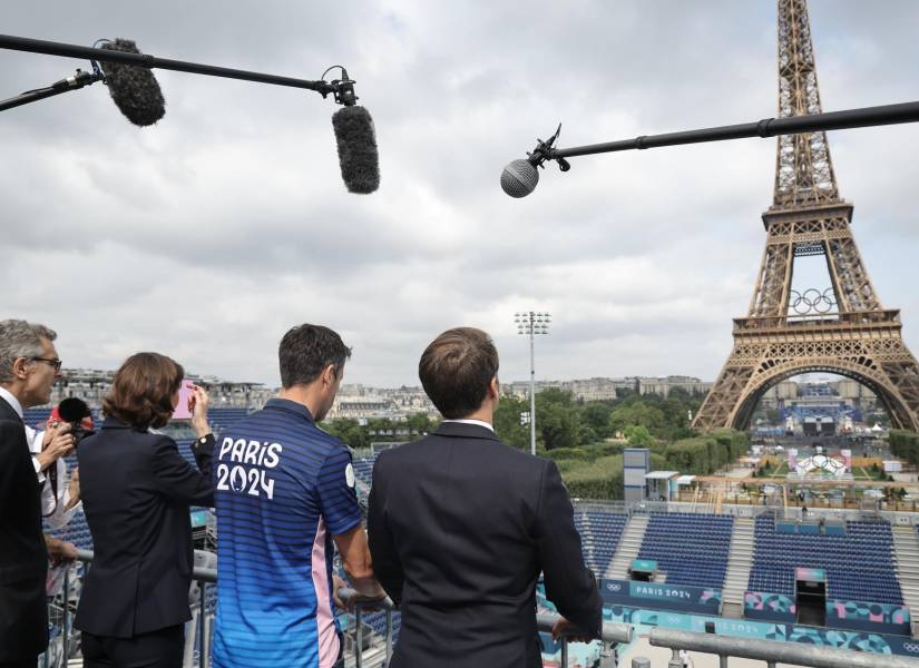 El presidente de Francia, junto a otros deportistas olímpicos, observando a la Torre Eiffel, lugar donde recibirá miles de espectadores para la ceremonia de inauguración