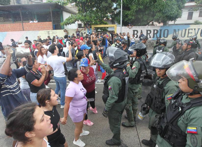 Personas reclaman frente a integrantes de la Guardia Nacional Bolivariana (GNB) durante una manifestación luego de los resultados de las elecciones presidenciales este lunes, en el sector del Primero de Mayo en Caracas (Venezuela). EFE/ Manuel Díaz