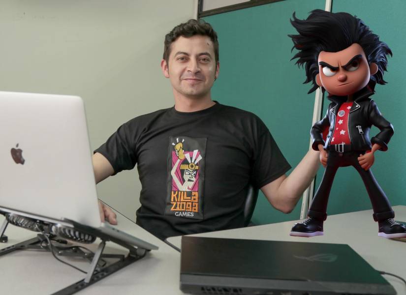 El diseñador ecuatoriano y director de Killa Zinga Games, Danny Oñate, posa con una representación del personaje protagonista del videojuego Capac Heroes.