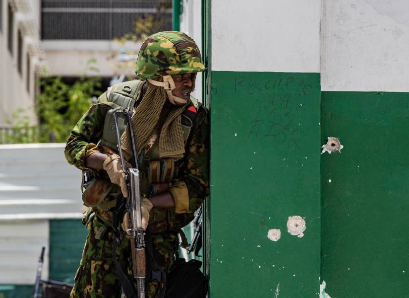 Fotografía de archivo del 29 de julio de 2024 de un policía keniano vigilando una calle luego de un ataque en Puerto Príncipe.