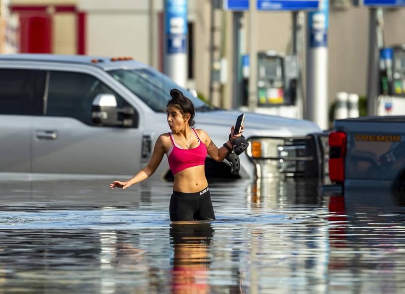 Mujer caminando en medio de las inundaciones por el huracán Beryl