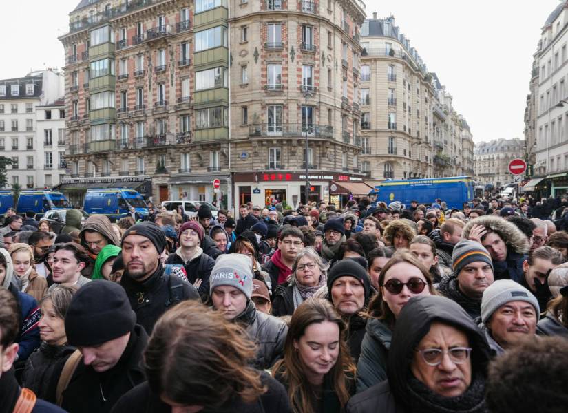 Ciudadanos y turistas esperan acercarse a la catedral de Notre Dame este sábado.