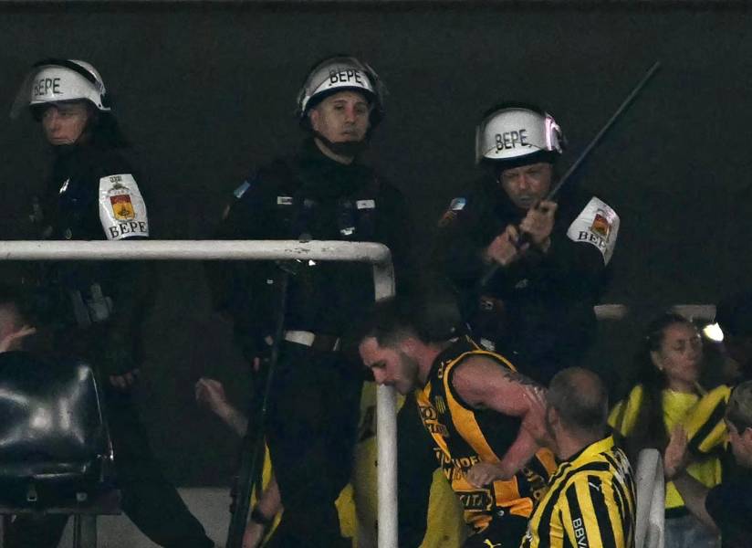 Agentes de la Policía brasileña intentando capturar a un hincha de Peñarol.