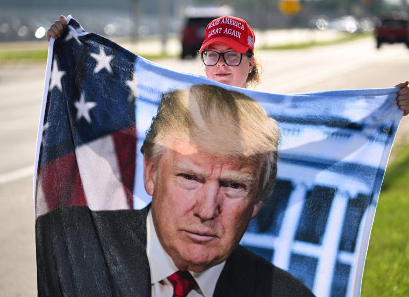 Una mujer sostiene un afiche de Trump en la ciudad de West Palm Beach, en Florida.