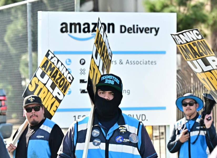 Trabajadores de Amazon caminan por la línea de piquete fuera de una instalación de Amazon en la ciudad de Industry, California.